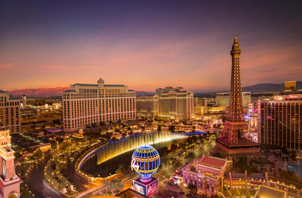 Stunning aerial view of Las Vegas skyline at sunset, featuring the Eiffel Tower and Bellagio fountains.