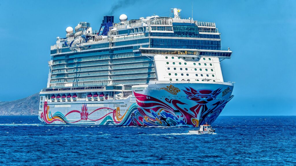 pexels-photo-945177-945177 A colorful cruise ship sailing on the open sea under a clear blue sky. Ideal for tourism and travel themes.